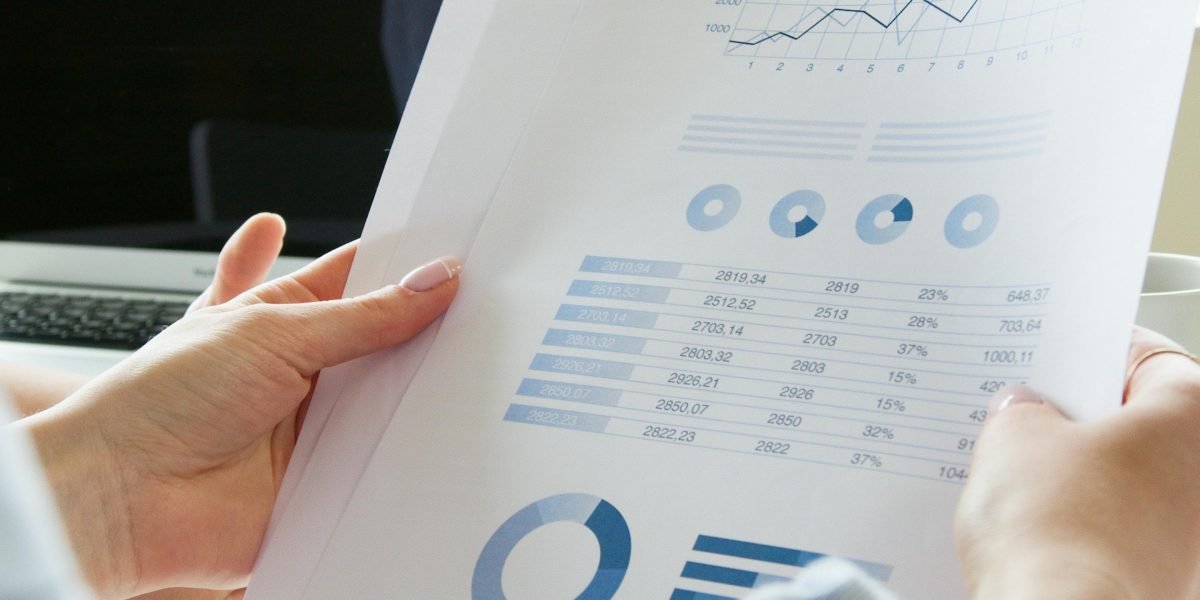 A person carefully reviewing financial documents and statements, symbolizing the evaluation of costs and potential return on investment for education.