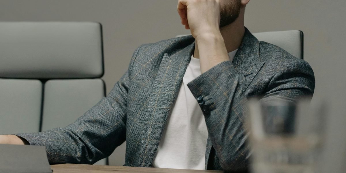 A professional contemplating a difficult choice, symbolizing the strategic decisions organizations face regarding AI adoption and manual oversight.