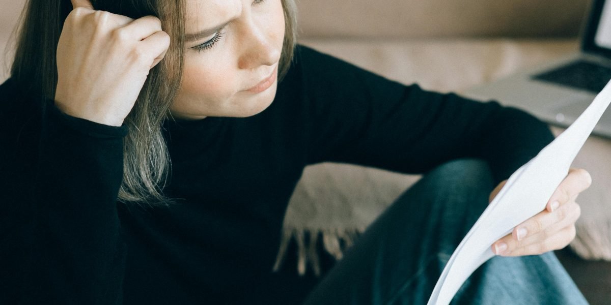 A business professional looking concerned while reviewing financial documents, symbolizing the monetary risks of AI hallucinations.