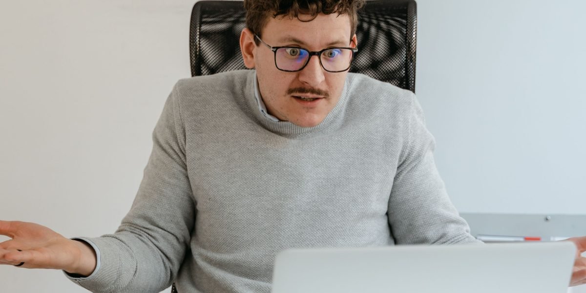 A person looking confused or concerned while examining an email on their device, reflecting the challenge of identifying sophisticated AI-generated phishing.