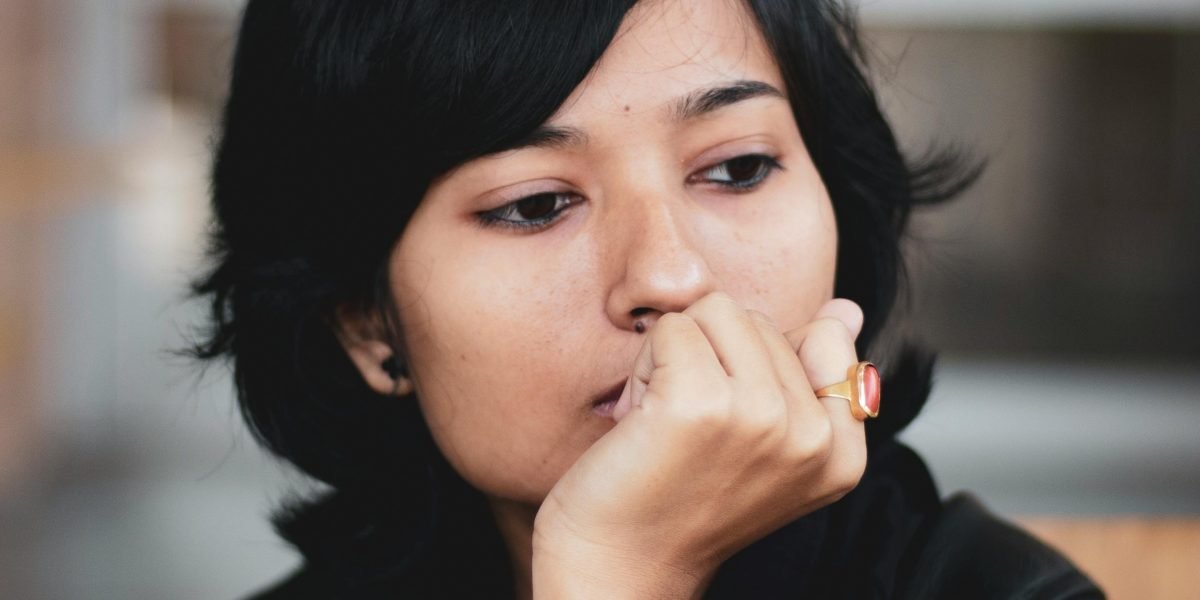 A person pausing and reflecting before making a decision, symbolizing the importance of verifying unexpected messages to avoid traps.
