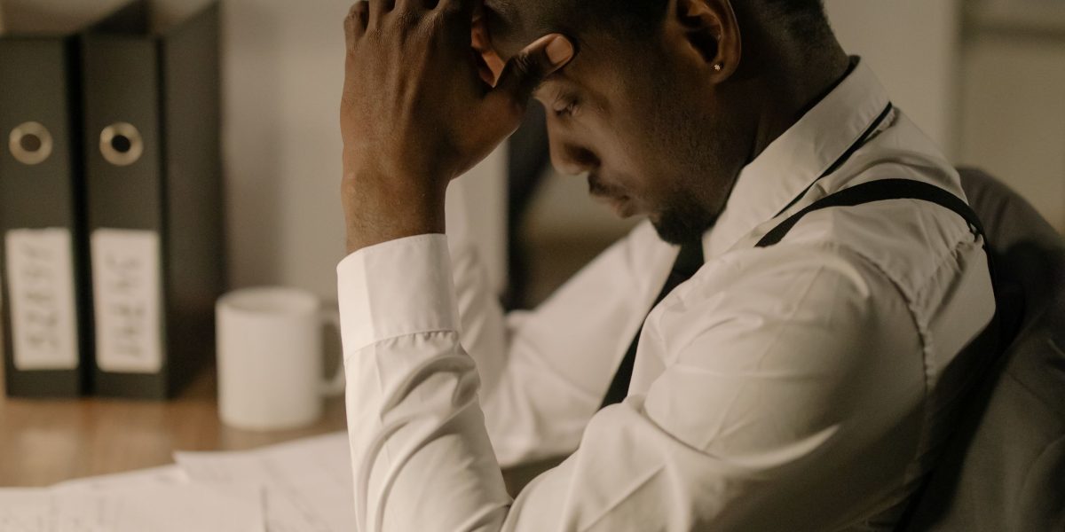 A person reviews documents with a worried expression, reflecting the stress and potential errors caused by stealth AI hallucinations.