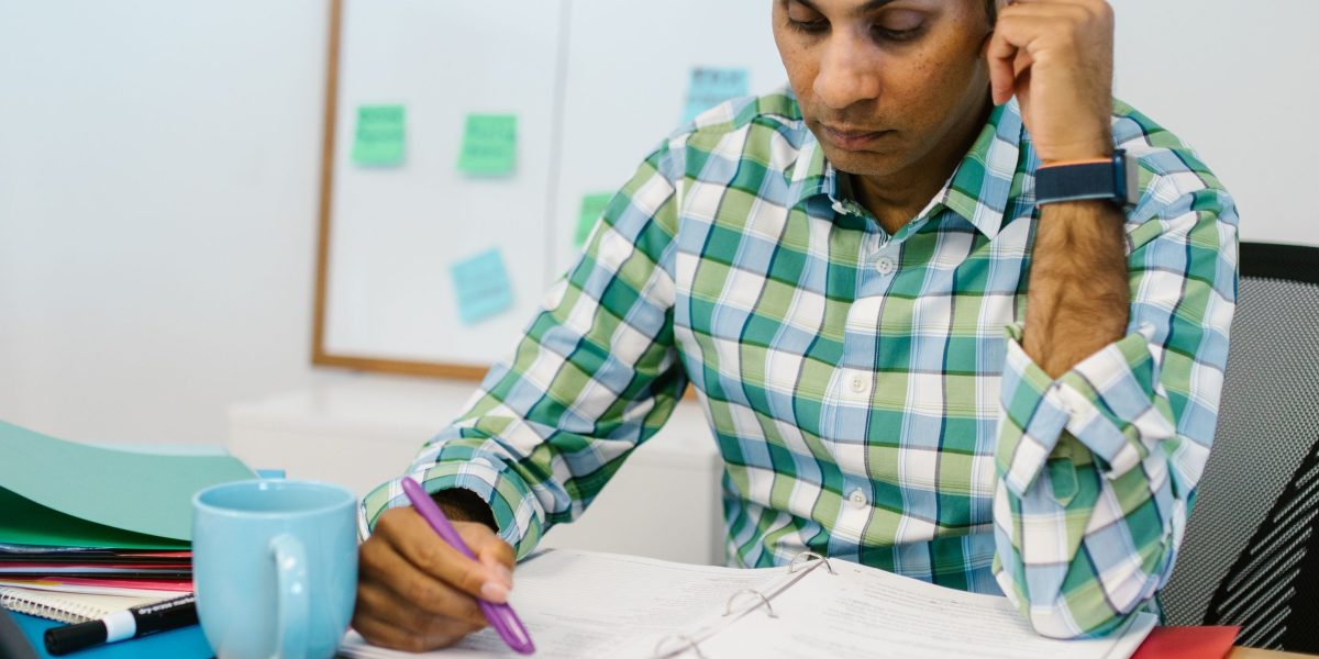 A person looking thoughtfully or skeptically at documents, representing the moment of realizing an AI's confident response was inaccurate.