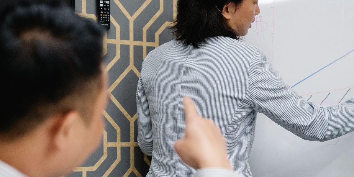 A team collaboratively analyzing data on a whiteboard, strategizing solutions for real-world data challenges and discrepancies.