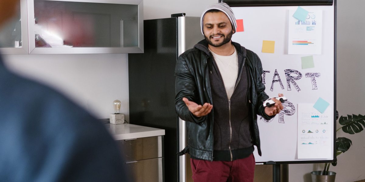 A professional clearly explaining a complex technical concept to colleagues during a team discussion or presentation.