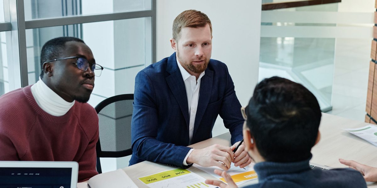 Two colleagues engaged in a focused discussion, reviewing documents related to secure data management in a professional setting.