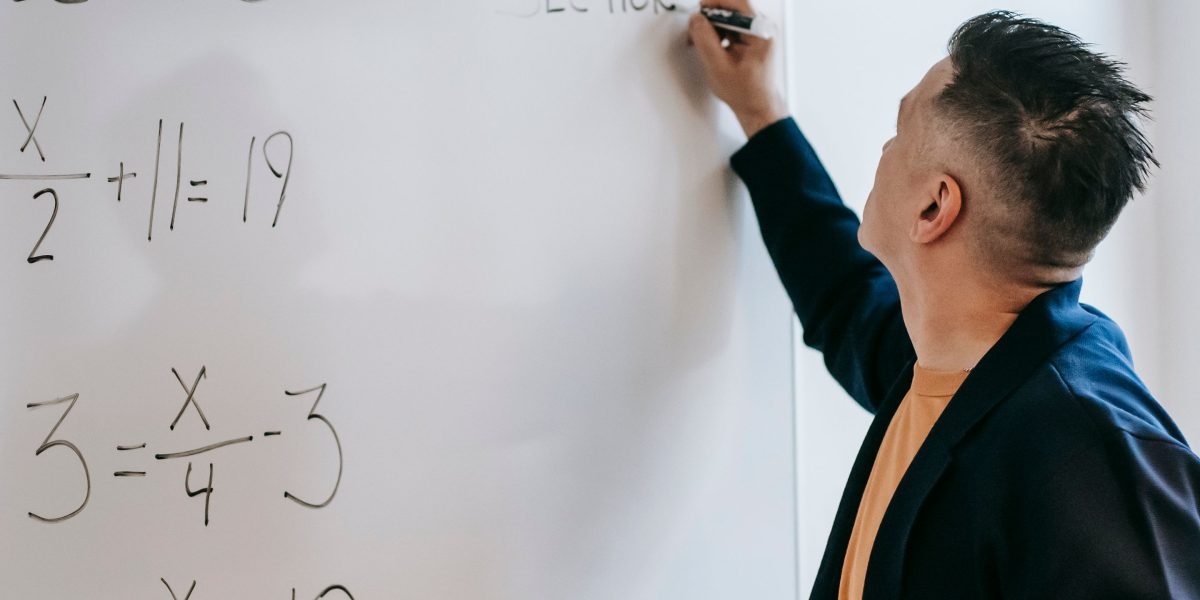 An individual deeply focused on a task, surrounded by notes and diagrams, actively working to resolve a complex technical issue.