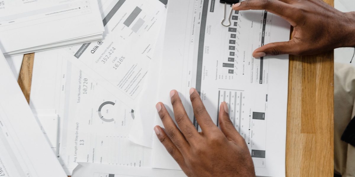 A group of professionals in a meeting, reviewing financial reports and discussing project budgets for cloud resource allocation.