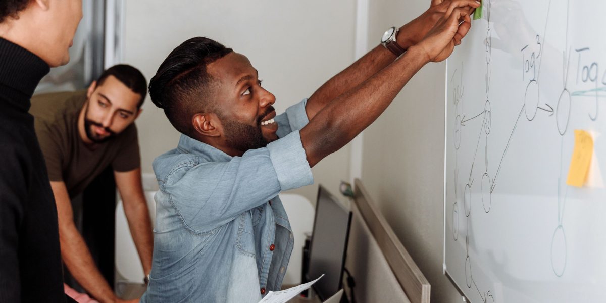 A dedicated team collaborating intensely on a technical strategy, emphasizing the complex engineering and architectural decisions needed for robust AI systems.